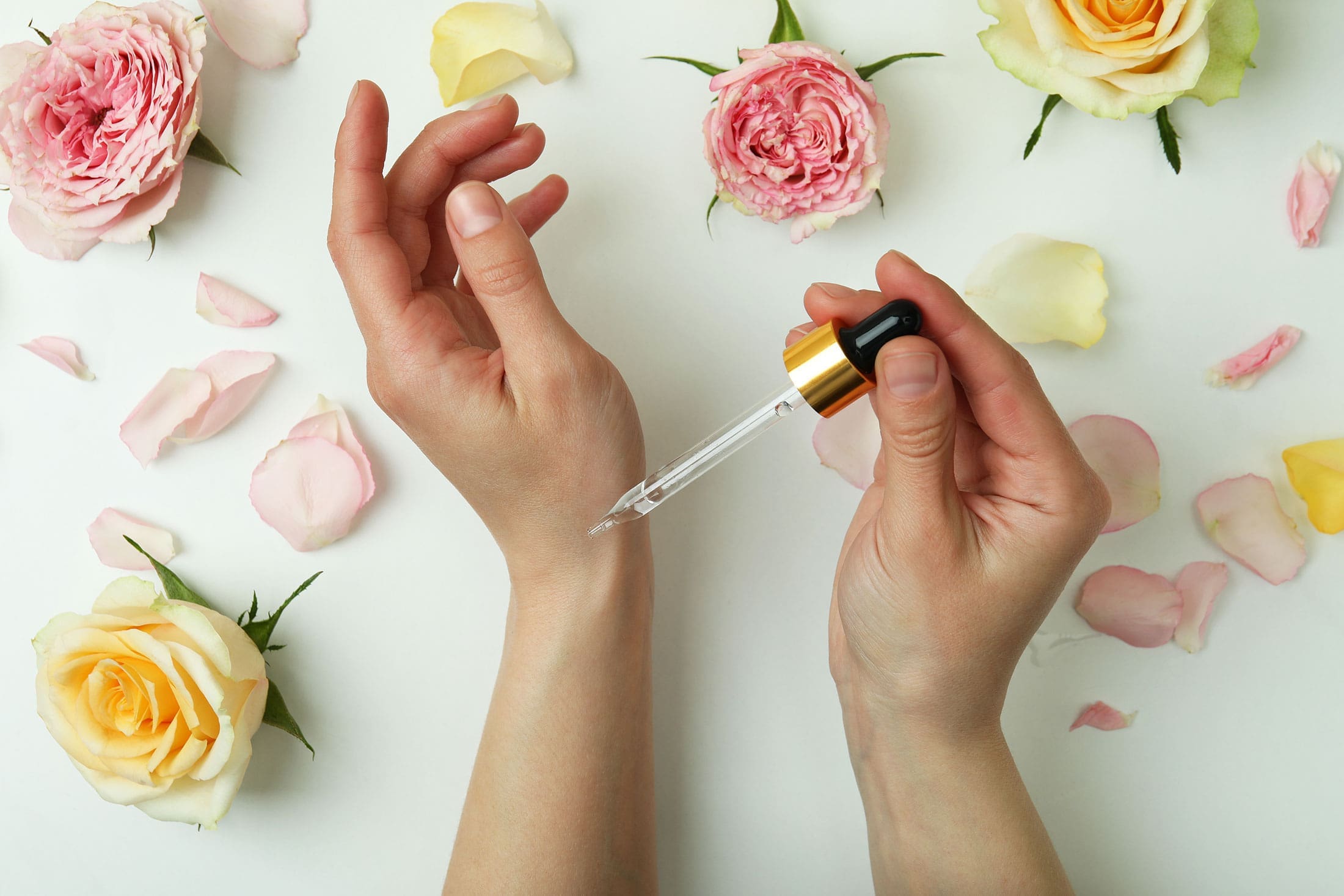 Hands around flowers using essential oils naturally
