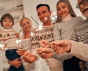 The happy family with bright sparklers during the holiday season, spending time together