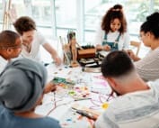 A group of young adults engaging in a group activity of painting and art therapy.