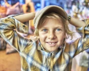 Smiling young boy in a colorful setting, symbolizing childhood joy and the importance of family mental health services during Mental Health Awareness Month.