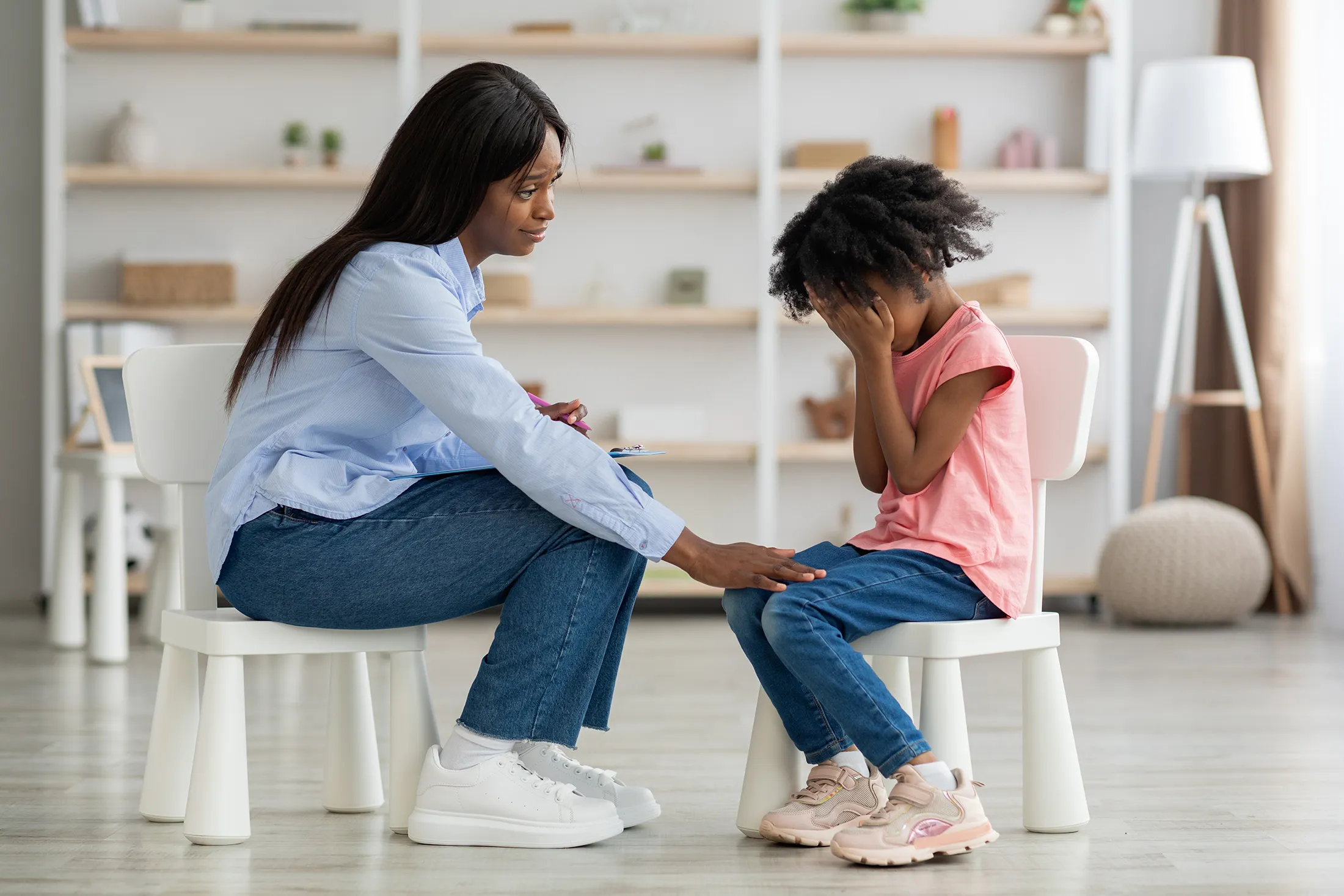 Therapist comforting a young girl during a grief counseling session.
